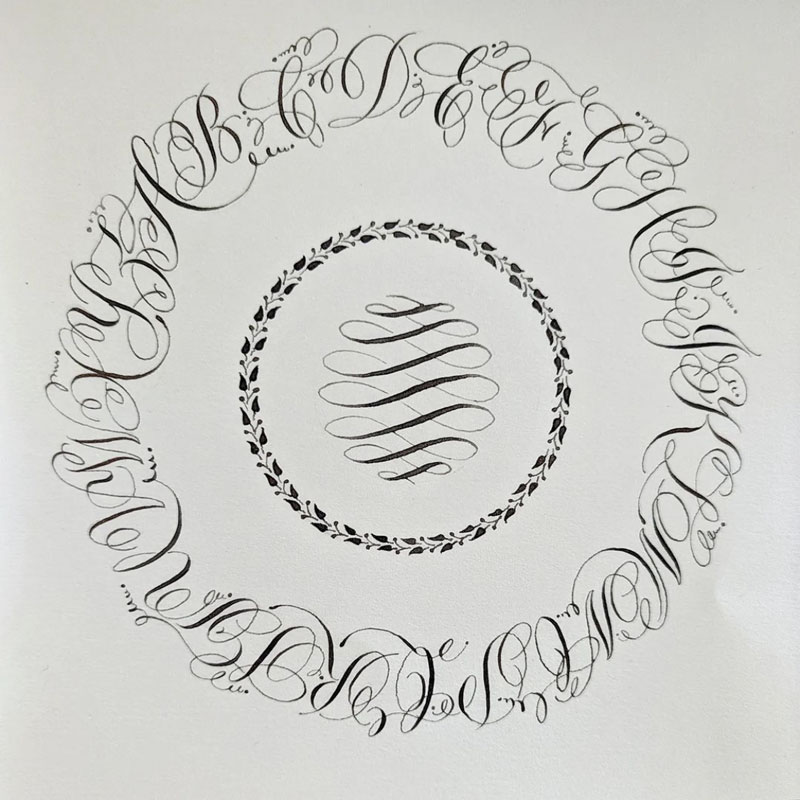 a calligraphic version of letters and flourishes on a circle by Miranda Songer